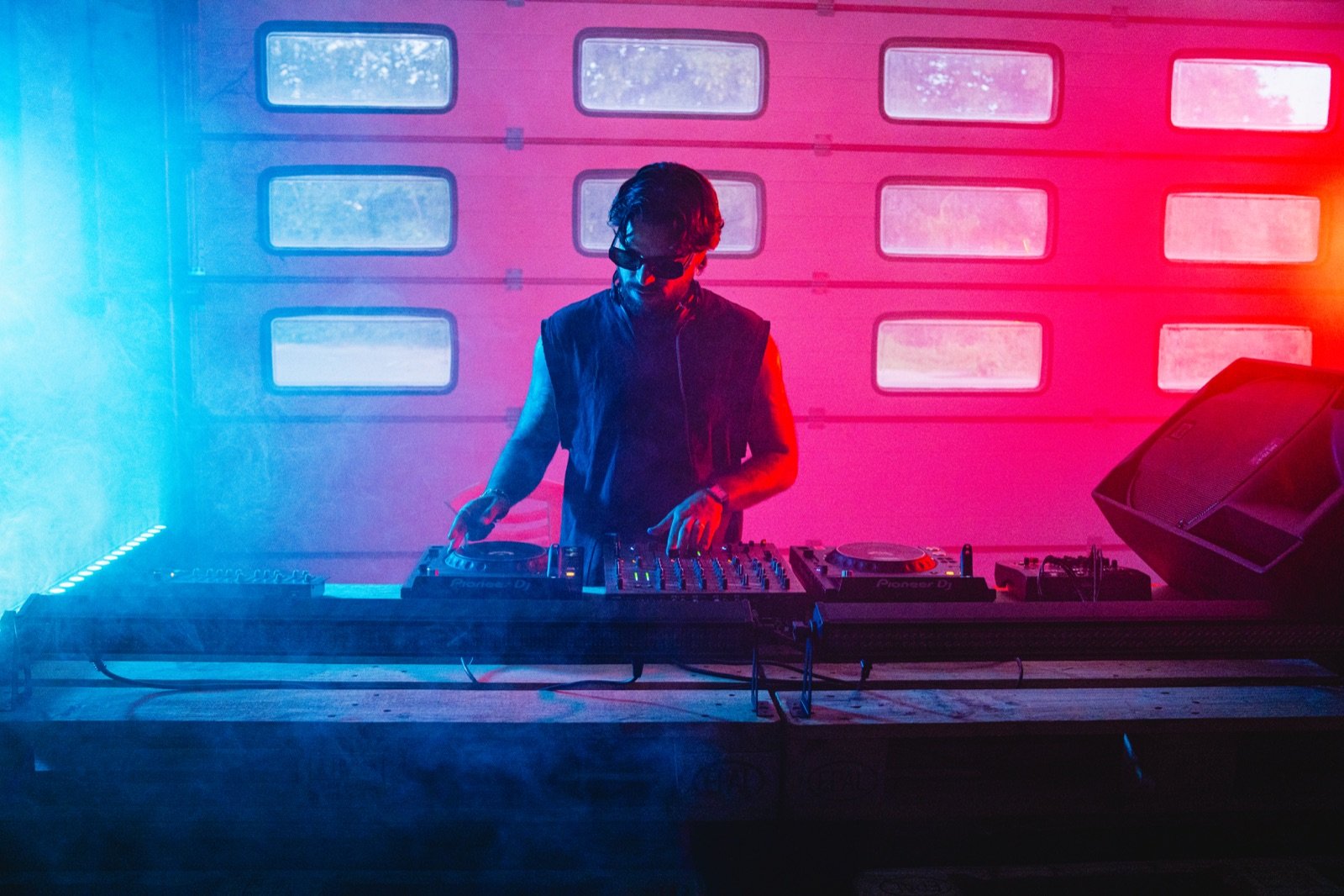 YELB beim Auflegen hinter dem Pioneer-Setup, in rotes und blaues Licht getaucht